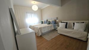 a bedroom with a bed and a couch at Odivelas Home in Odivelas
