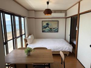 a small room with a bed and a table at 指宿 潮音 Ibusuki Shione in Ibusuki