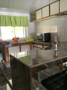 a kitchen with a large marble counter top at Sarahlodge in Tahaa