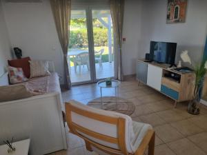 a living room with a couch and a tv at Mini Villa 200 m de la plage in Cervione
