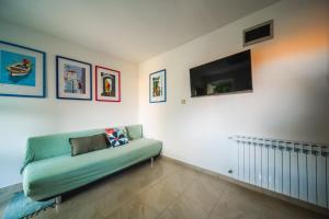 a living room with a green couch and a flat screen tv at Apartment and rooms Jurišić in Korčula