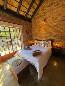 a bedroom with a large bed in a brick wall at Bush and Gables in Marloth Park +36 photos
