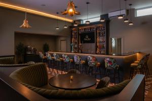 a restaurant with a bar with chairs and a table at Arden House in Dingle