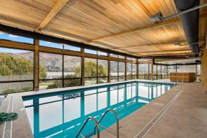 a large swimming pool with a wooden ceiling and windows at Luxuy Vista in Wanaka
