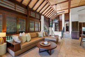a living room with a couch and a table at Monsoon Villa A - Central Balinese-style Pool Oasis in Port Douglas