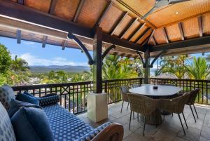 a patio with a table and chairs on a balcony at Monsoon Villa A - Central Balinese-style Pool Oasis in Port Douglas