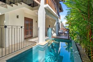 a villa with a swimming pool and a house at Monsoon Villa A - Central Balinese-style Pool Oasis in Port Douglas