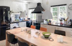 a kitchen with a wooden table with chairs in it at Gorgeous Home In Hundested With Wifi in Hundested