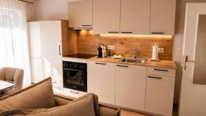 a kitchen with white cabinets and a sink at Michelis Cottage - Achensee in Pertisau