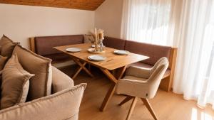 a dining room table with two chairs and a wooden table at Michelis Cottage - Achensee in Pertisau