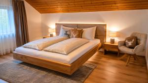 a bedroom with a large bed and a chair at Michelis Cottage - Achensee in Pertisau