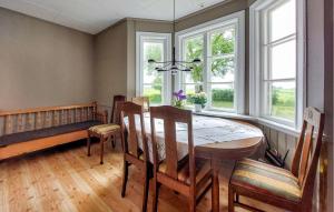 a dining room with a table and chairs and windows at Paulinas Hus in Laholm