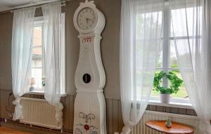 a white grandfather clock in a room with windows at Paulinas Hus in Laholm
