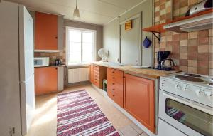 a kitchen with orange cabinets and a stove top oven at Paulinas Hus in Laholm