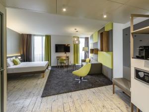 a hotel room with a bed and a desk at Novotel München Messe in Munich