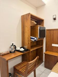 a room with a wooden desk and a tv at Aruvi on the cliff in Varkala
