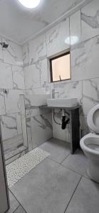 a white bathroom with a sink and a toilet at Co operville in Potchefstroom +2 photos