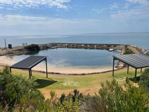 a park with a bench and a body of water at Jack's Tidal Pool Shack Kingscote in Kingscote