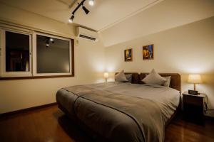a bedroom with a bed with two lamps and a window at Villa Qualite ヴィラカリテ in Zao +22 photos