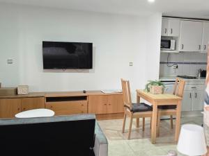 a kitchen with a table and a tv on the wall at apto La Campana in Toledo