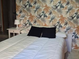 a bed in a bedroom with a floral wallpaper at apto La Campana in Toledo