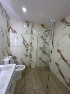 a bathroom with a toilet and a glass shower at WHTheGroundNest in Paralimni