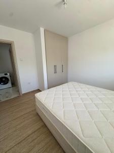 a white bedroom with a large bed in it at WHTheGroundNest in Paralimni