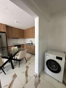 a kitchen with a washing machine and a table at WHTheGroundNest in Paralimni