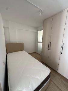 a small room with a bed and a cabinet at WHTheGroundNest in Paralimni +2 photos