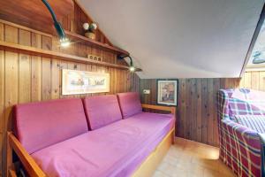 a red couch in a room with wooden walls at Snow paradise in Naut Aran
