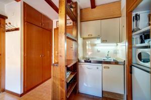 a kitchen with white appliances and wooden cabinets at Snow paradise in Naut Aran
