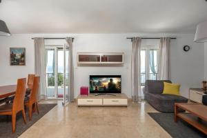 a living room with a couch and a television at Hillside Villa Kvarner: Pool & Sea View - Happy Rentals in Ičići
