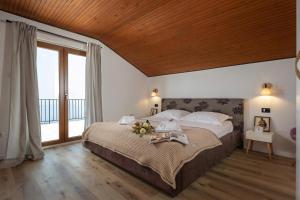 a bedroom with a large bed with a wooden ceiling at Hillside Villa Kvarner: Pool & Sea View - Happy Rentals in Ičići
