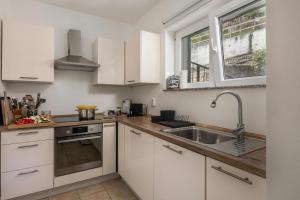 a kitchen with white cabinets and a sink at Hillside Villa Kvarner: Pool & Sea View - Happy Rentals in Ičići