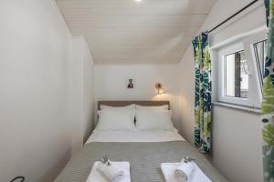 a small bedroom with a bed with two pillows at Hillside Villa Kvarner: Pool & Sea View - Happy Rentals in Ičići +33 photos