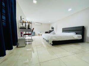 a bedroom with a large bed and a table at Balcony Garden Studio in Johor Bahru