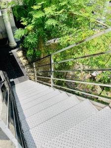 an ascending stairway with a metal railing and trees at Balcony Garden Studio in Johor Bahru