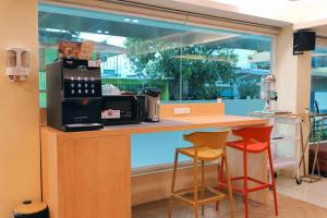 a counter with two stools and a microwave on it at Tubtim Siam Suvarnabhumi Hotel in Bang Phli