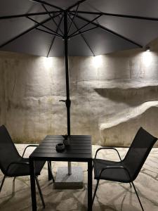 a table with two chairs and an umbrella at K&L Luxury Suite 2 in Parga