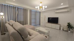 a living room with a couch and a flat screen tv at Chillax Townhome 65 in Hua Hin