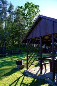 a wooden pavilion with a picnic table in a park at Kalva Sumowo in Sumowo