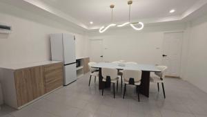 a kitchen with a table and chairs and a refrigerator at Chillax Townhome 65 in Hua Hin