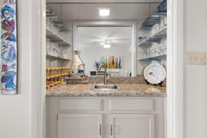 a kitchen with a sink and a counter with shelves at Edgewater Condo Unit #304 in South Padre Island
