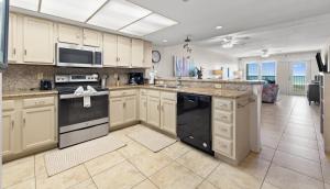 a large kitchen with white cabinets and black appliances at Edgewater Condo Unit #304 in South Padre Island +18 photos