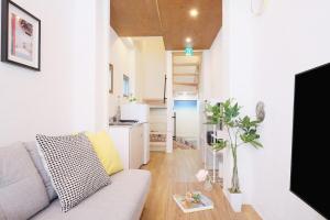 a living room with a couch and a kitchen at Dearcourt Kichijoji 1F-3F in Musashino