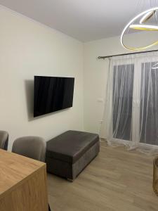 a living room with a bed and a flat screen tv at K&L Luxury Suite 2 in Parga