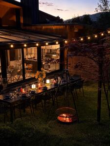 an outdoor dining area with tables and lights at night at Dom i Las in Brenna