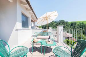 a patio with a table and chairs on a balcony at L'Attico di Asilo in Barolo in Barolo
