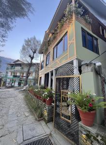 a house with potted plants in front of it at The AISHANA PAHALGAM in Pahalgām +4 photos