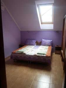 a bedroom with a large bed with a window at Marinica Apartman in Hajdúszoboszló